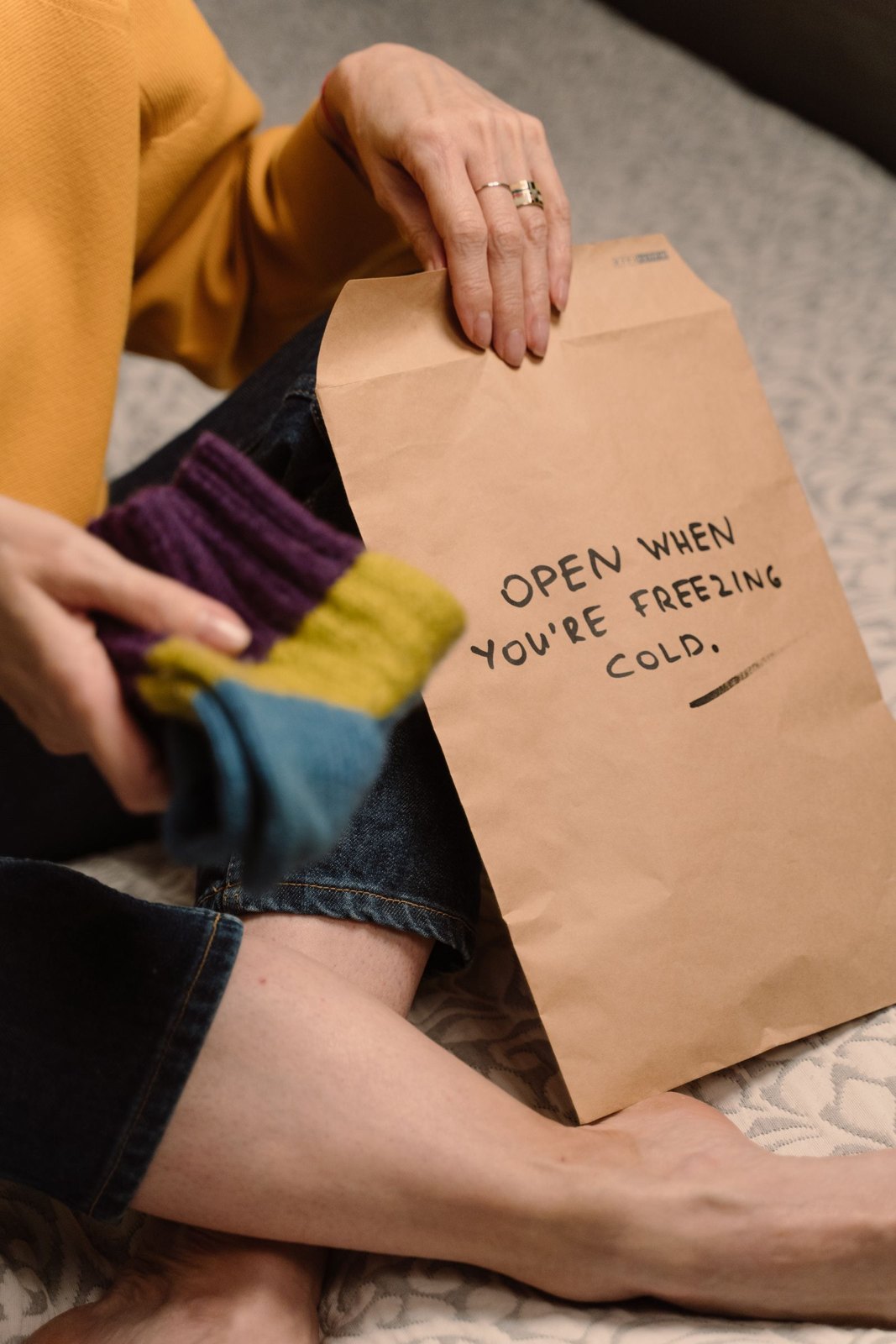 A gift bag labelled for a cold day with colourful knitwear
