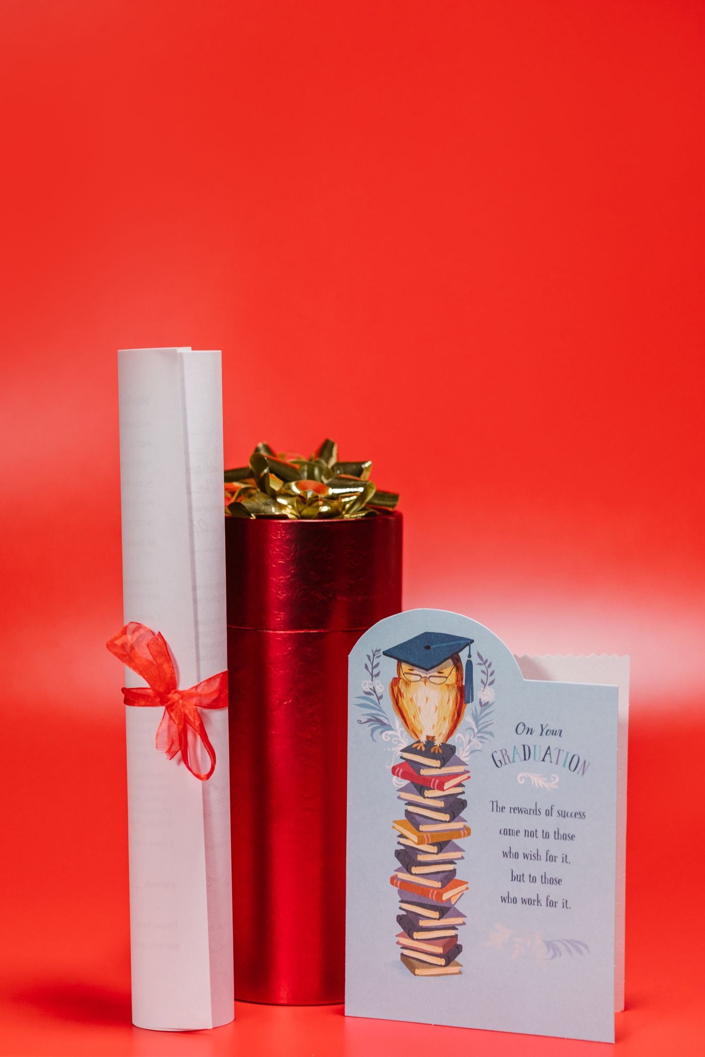A wrapped graduation present beside a rolled diploma