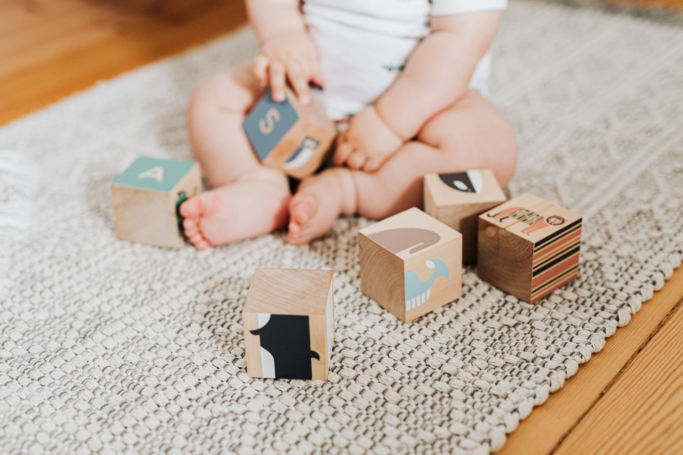 A baby playing with wooden alphabet blocks
