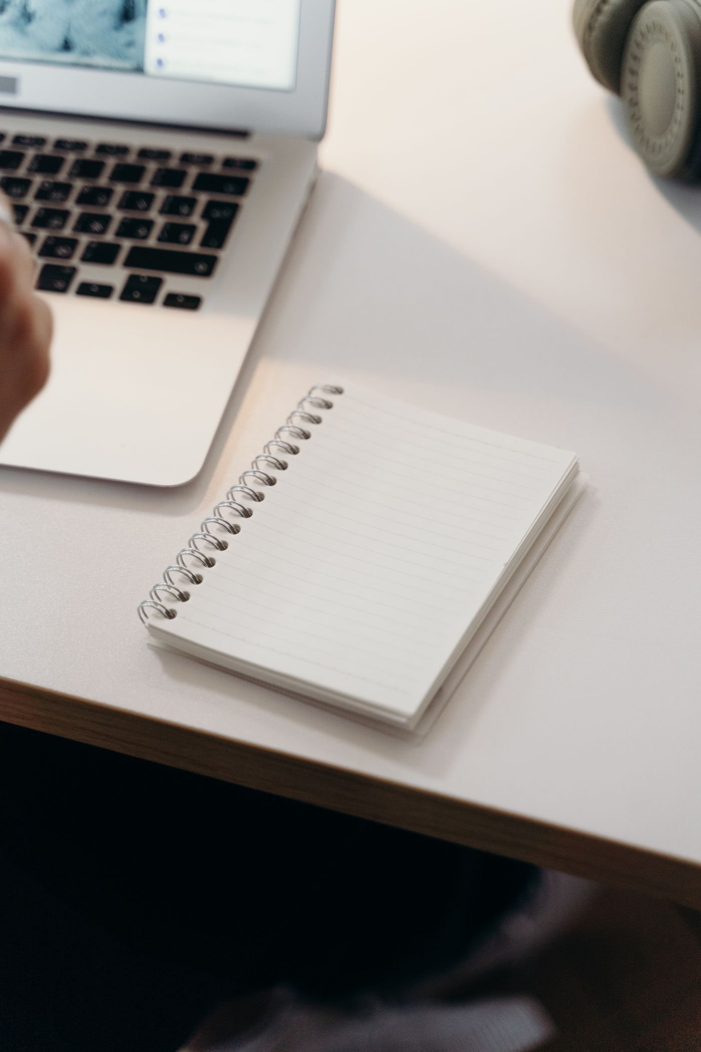 A notebook and laptop on a clean desk