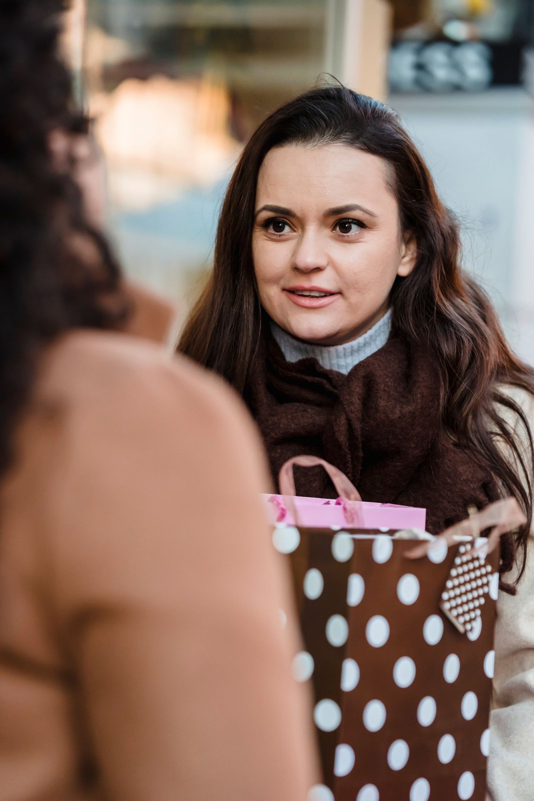 Friends talking at an outdoor table with gift bags