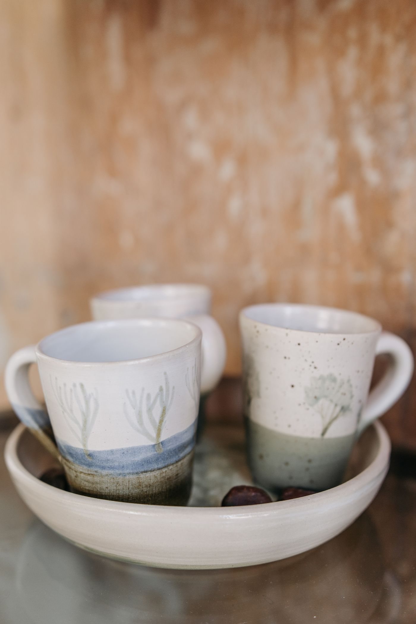 Handmade ceramic mugs arranged on a ceramic tray