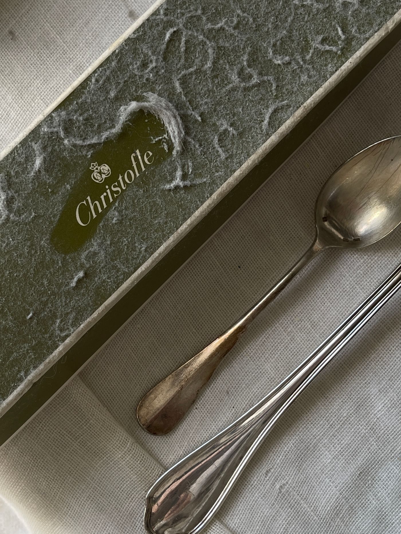 A silver keepsake spoon beside its presentation box