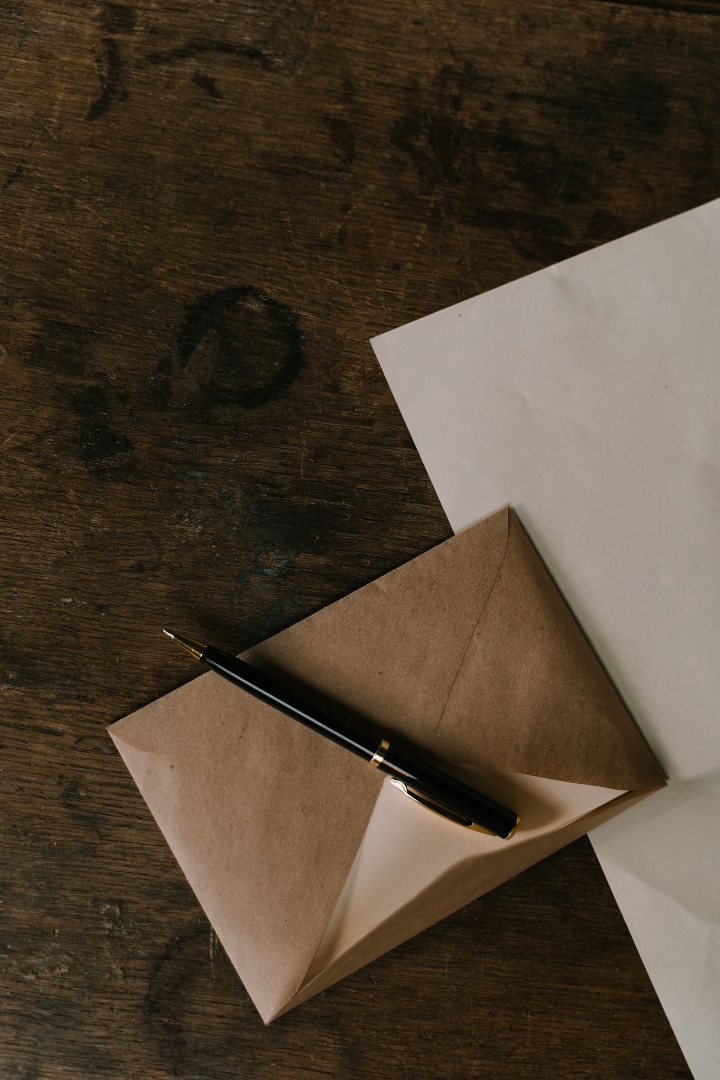 A black pen resting on a paper envelope