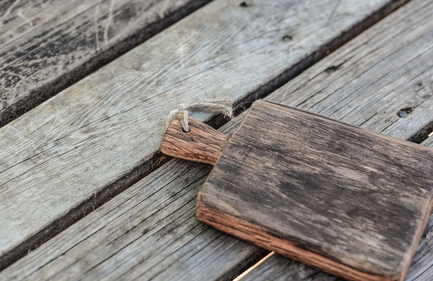 Plain wooden chopping board on a rustic table