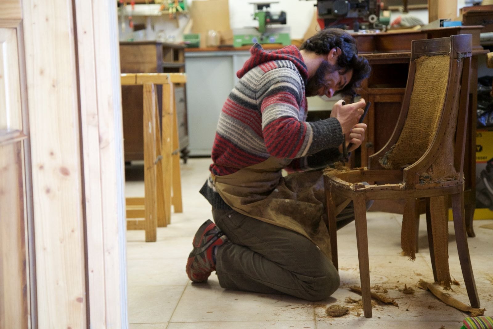 A craftsperson restoring the details of a wooden chair