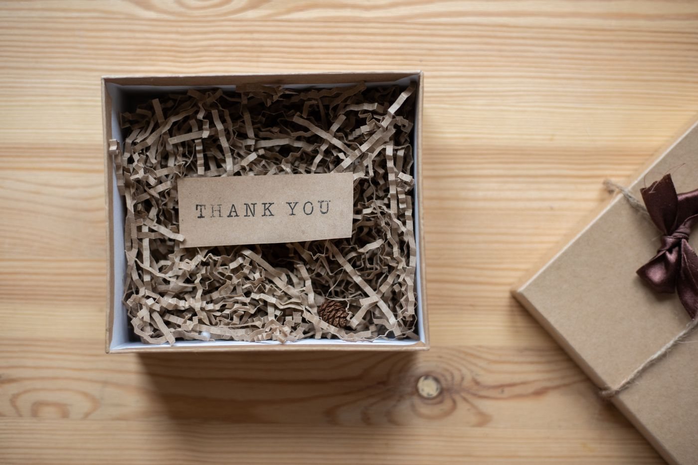 An open cardboard gift box with a small note