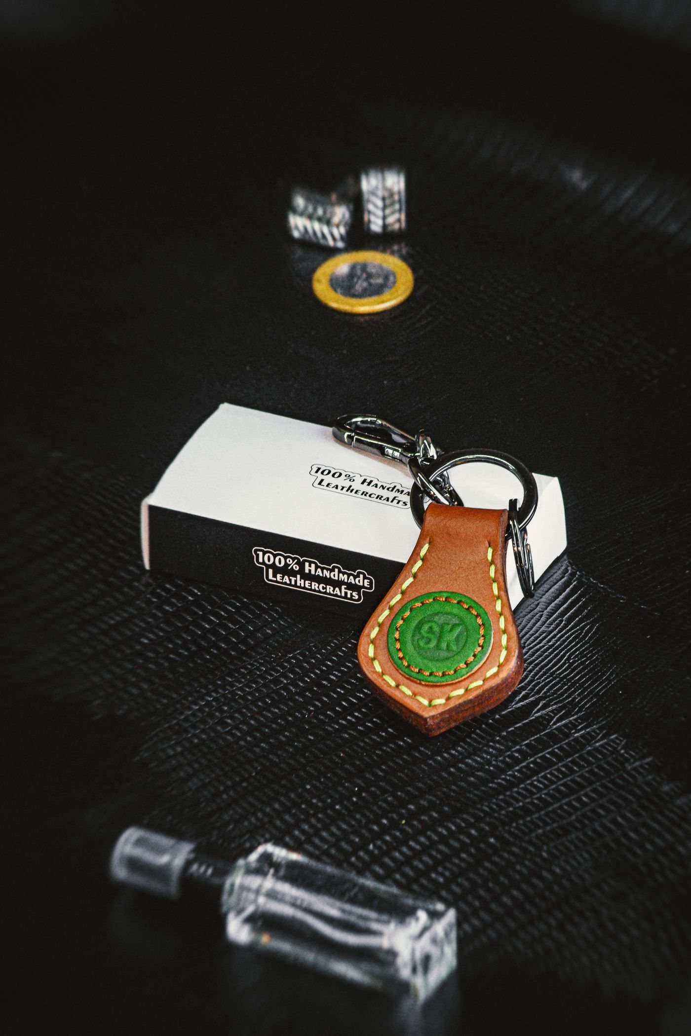 Handcrafted leather keyring on a dark textured surface