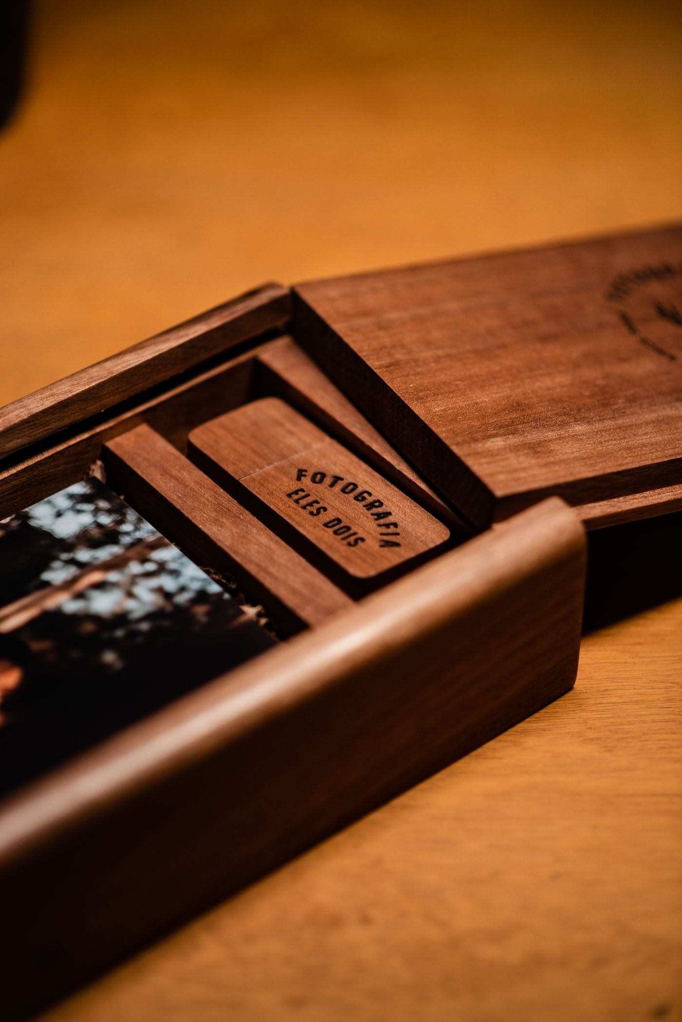 A wooden keepsake box containing printed photographs