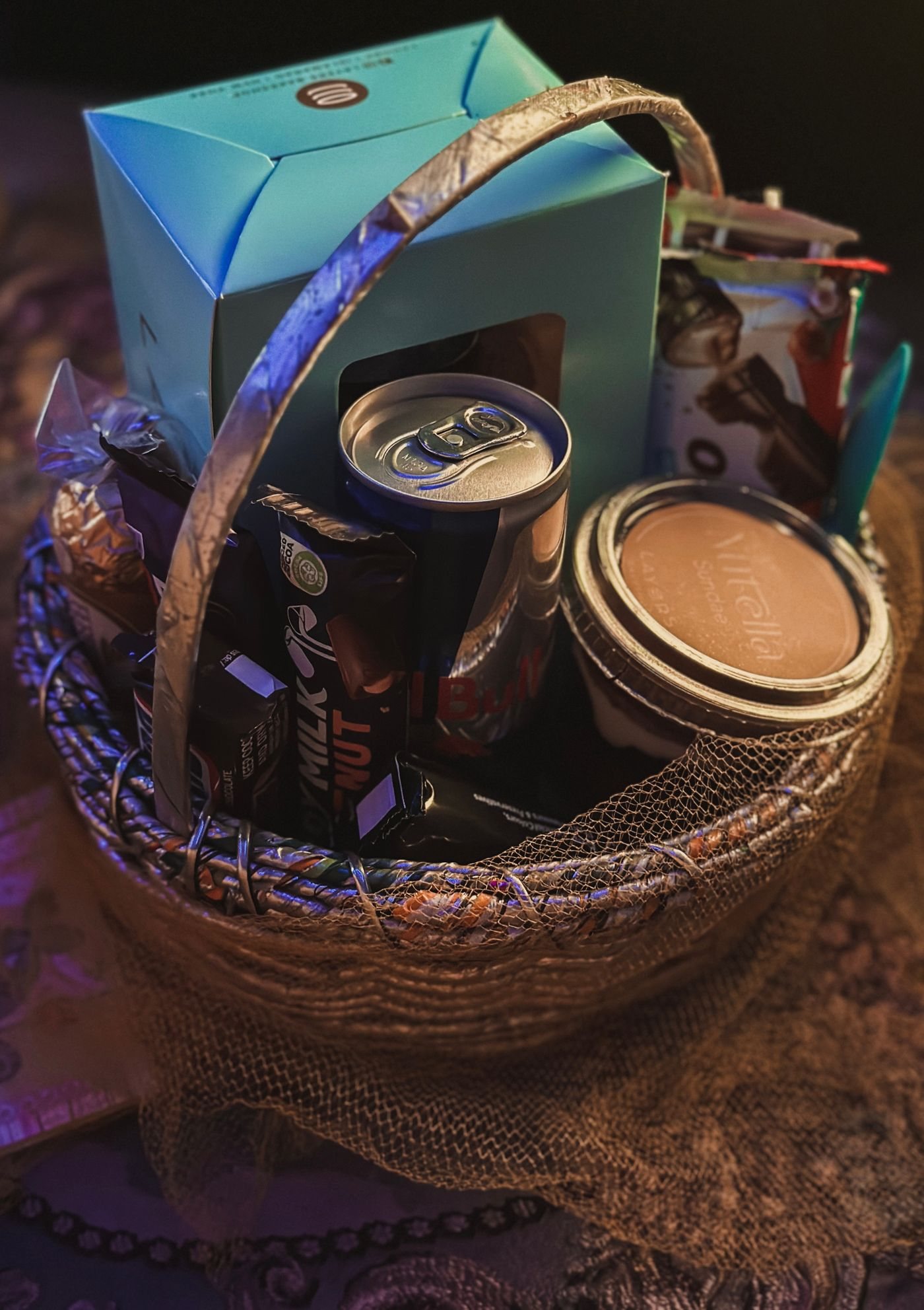 A basket containing packaged food, a drink and a cup