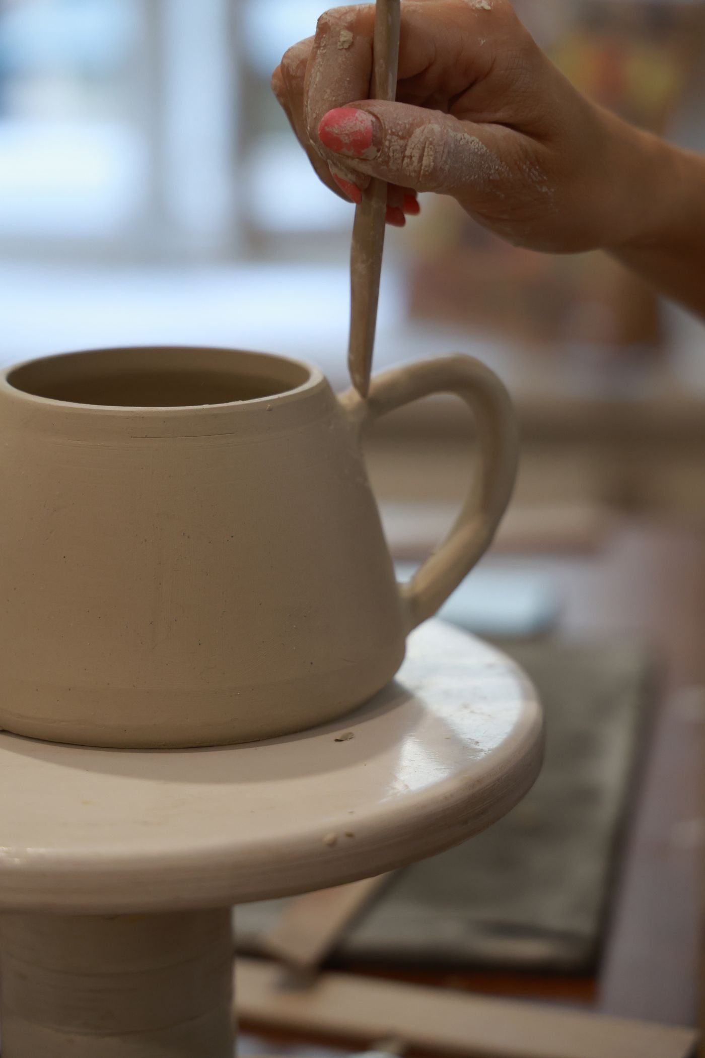 A maker shaping a pottery cup by hand