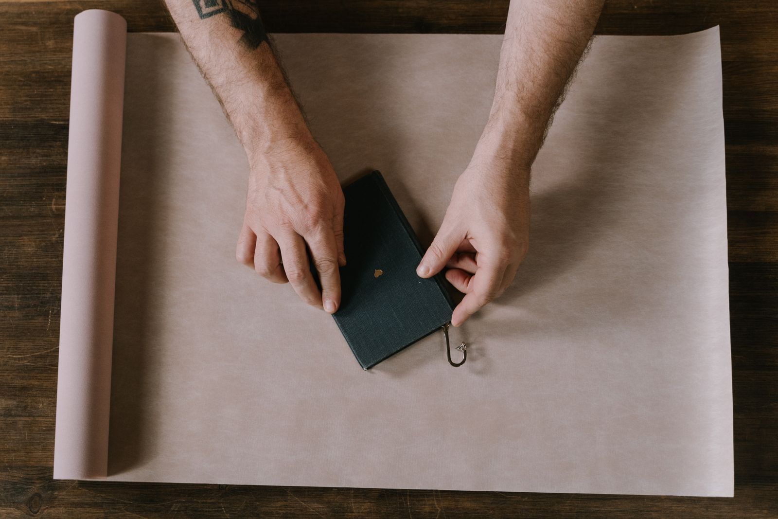 Hands positioning a book on brown wrapping paper