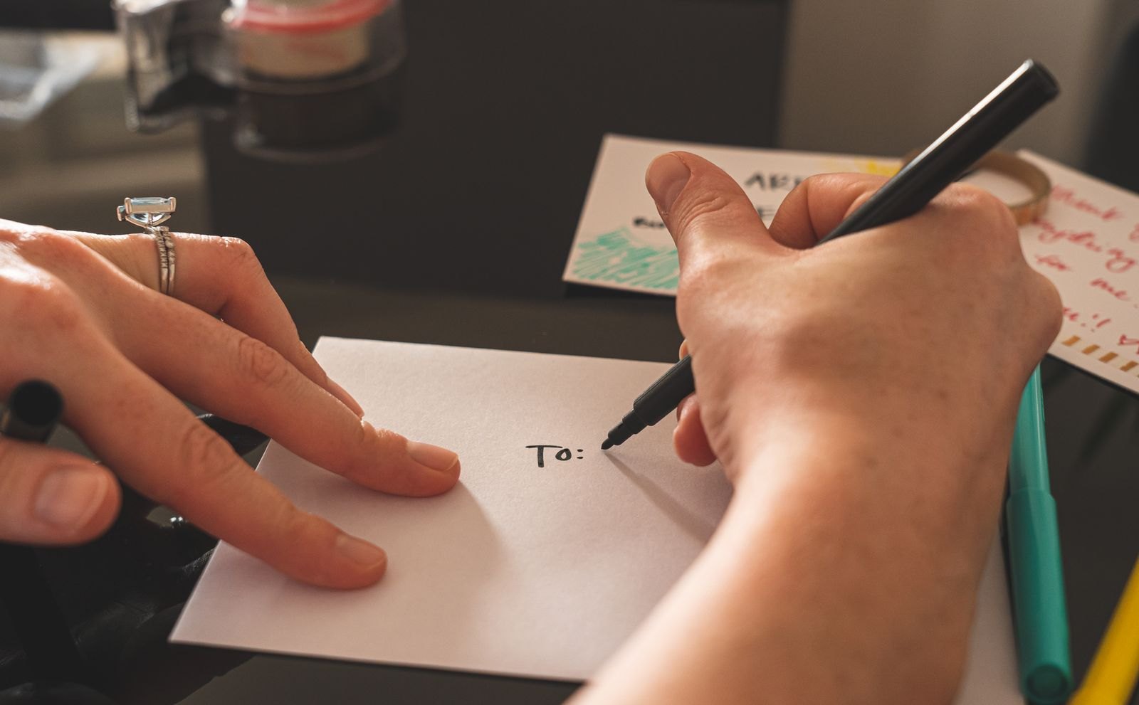 Hands addressing a handwritten note with a marker